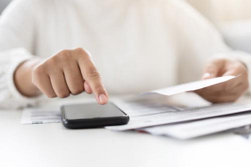 Woman using a calculator to check her tax code